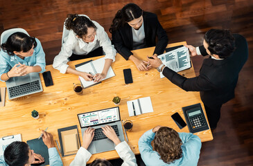 Panorama top view diverse group of business analyst team analyzing financial data report paper on meeting table. Chart and graph dashboard by business intelligence analysis. Meticulous