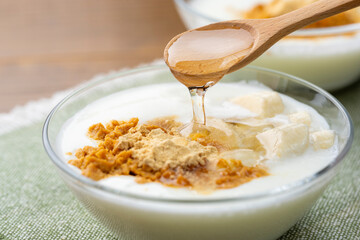 きな粉トッピングしたバナナヨーグルトにオリゴ糖をかける