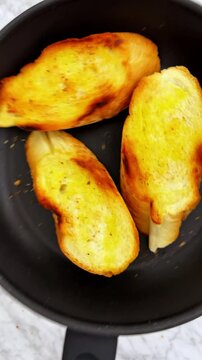 Toasting french baguette on frying pan