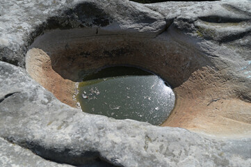 The depression in the stone was created over time under the influence of rain and other atmospheric...