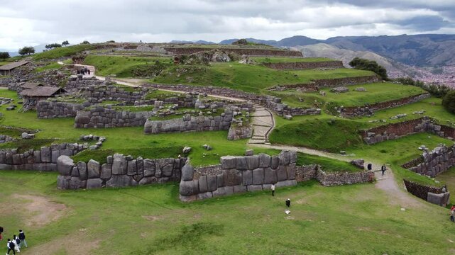 Tourists walking around the sacsayhuaman fortress, an inca archaeological site near cusco, peru