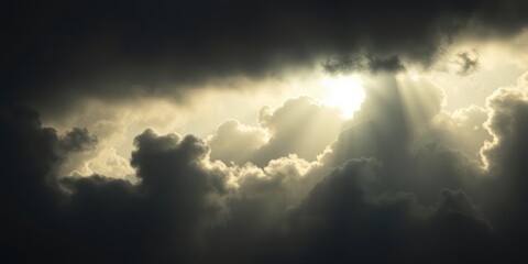 Obraz premium Rays of light illuminate dark clouds, creating a moment that evokes feelings of hope, spiritual enlightenment, and connection with God during sacred occasions