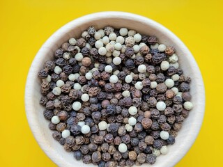 Pile of white and black pepper seeds for great taste.