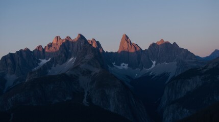 Fototapeta premium Majestic Mountain Peaks Bathed in Warm Sunset Light at Dusk