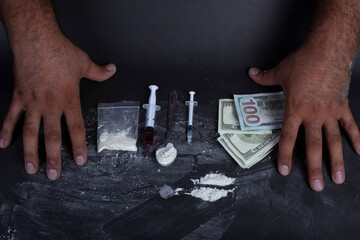 Man's hands trying to abstain from drugs on dark table with cookedcocaine