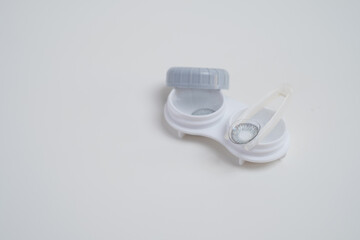 Contact lenses, case and bottle with solution and eye drops on white background. Eye health and care, vision, ophthalmology concept, close-up