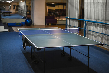 Tennis table in the gym. Sports equipment.