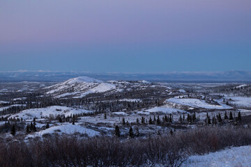 Aerial view of snow covered hills, trees and roads in interior Alaska