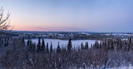 Icy, snowy lake under pink sky in Alaska