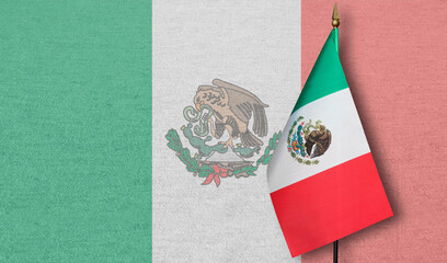 A small Mexico flag with a faint image of the Mexico flag in the background