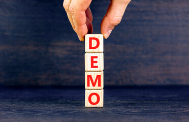 Demo symbol. Concept word Demo on beautiful wooden blocks. Businessman hand. Beautiful black table...