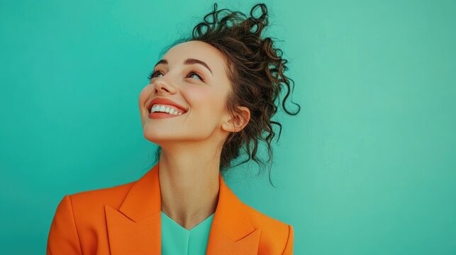 A confident woman in an orange blazer smiles brightly against a teal background, symbolizing empowerment and positivity. Ideal for Women's Day, fashion, and motivational themes