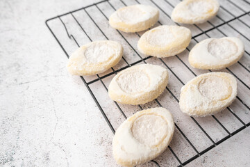 Italian lemon sugar cookies on a white plate. Powder sugar covered cookies.