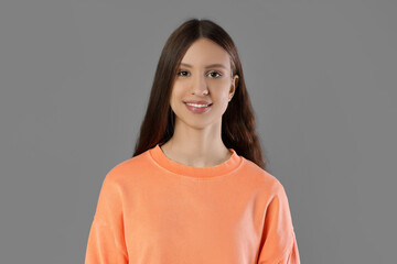 Portrait of smiling teenage girl on grey background