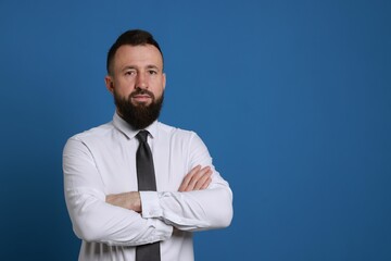 Handsome bearded man in formal outfit on blue background. Space for text