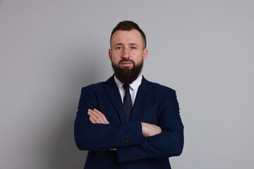 Handsome bearded man in suit on grey background