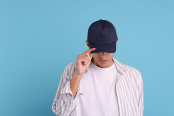 Man in stylish baseball cap on light blue background. Mockup for design