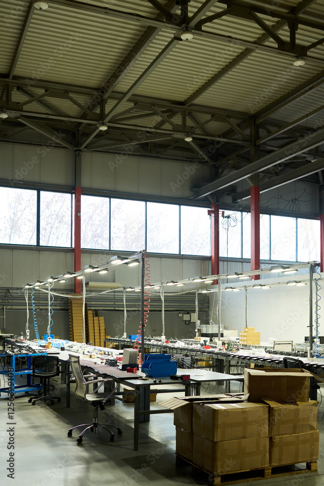 Poster Long tables with variety of working equipment for producing new items in spacious workshop of modern factory