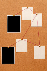 Blank paper notes and an empty photo are pinned to a cork board. The concept of detective investigation.