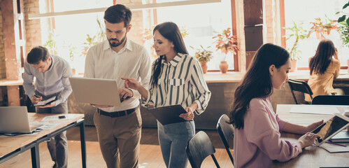 Focused leader coach collar man woman work laptop clipboard have conference decide document start...