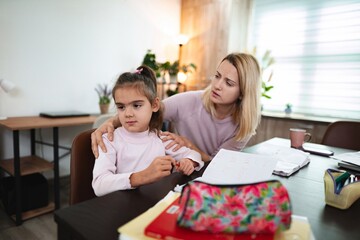 Mother comforts daughter during a challenging study session at home
