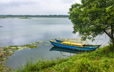 Empty blue catamaran on Hiriwadunna lake, Sigiriya, Sri Lanka