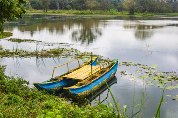 Empty blue catamaran on Hiriwadunna lake, Sigiriya, Sri Lanka