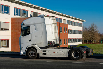 Fototapeta premium White truck parked near a modern building in clear weather