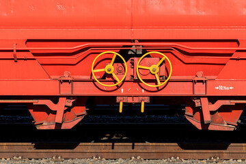 Detailed view of equipment on a red freight train car at a rail yard