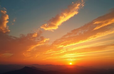 Fototapeta premium Vibrant sunset over mountain silhouettes with orange, golden colors in sky. Cloudscape in bright sunlight at dawn. Scenic natural background with freedom feel, peace and fresh air.