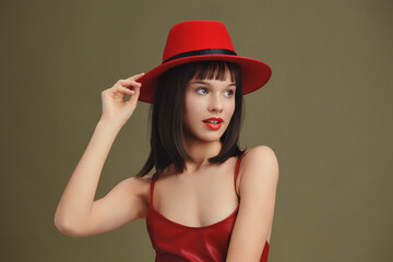 Red hat, red dress, posing woman, hands on hips, head tilted a stylish woman in a red hat and red...