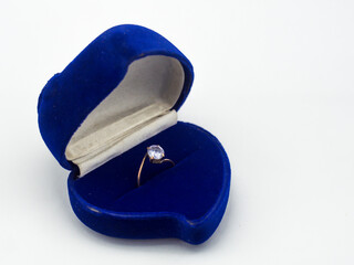 Clear stone ring in blue velvet box, isolated on white background