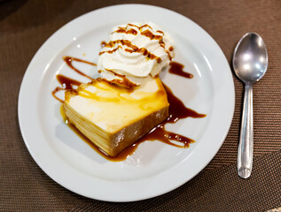 Creamy flan dessert served on platter with topping