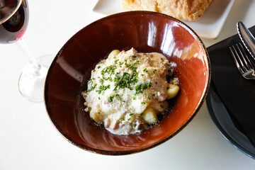 Delicious gnocchi alla carbonara with grated hard cheese and cream sauce served on clay plate. Italian pasta dish