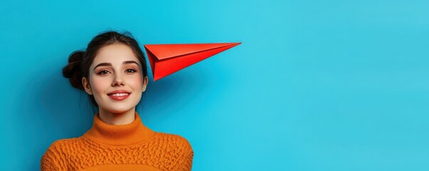 Young caucasian female with red paper airplane on blue background