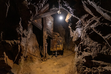Exploring an abandoned underground mine with rusted equipment and dim lighting, highlighting the remnants of a once-active mining site in a remote location