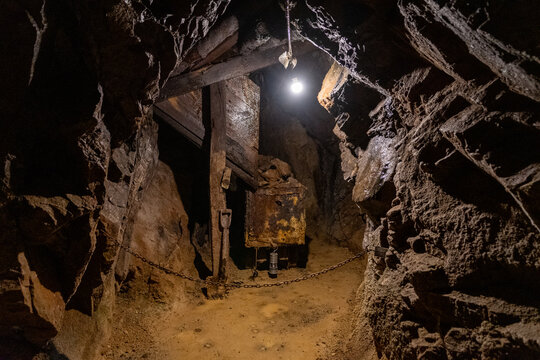 Exploring an abandoned underground mine with rusted equipment and dim lighting, highlighting the remnants of a once-active mining site in a remote location