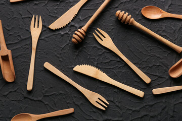 Different wooden kitchen utensils on black background