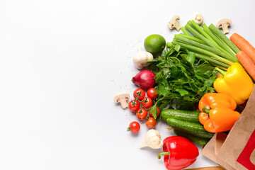 Paper bag with fresh vegetables, fruits and mushrooms on white background