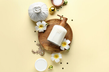 Beautiful spa composition with Christmas decorations and tropical flowers on color background