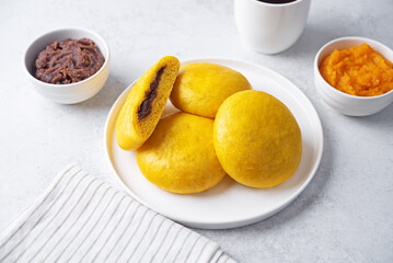 Pumpkin steamed buns with red bean paste filling in a plate