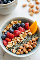 The image shows a bowl filled with various fruits and nuts, including strawberries, blueberries, blackberries, almonds, and granola