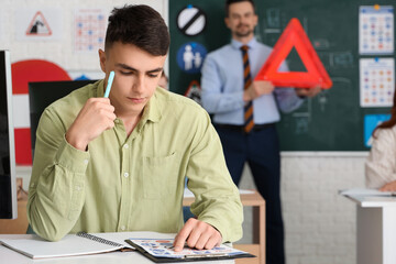 Young man learning road signs at driving school