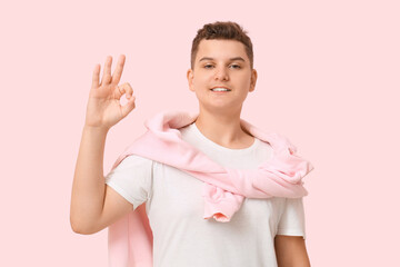 Teenage boy showing OK on pink background