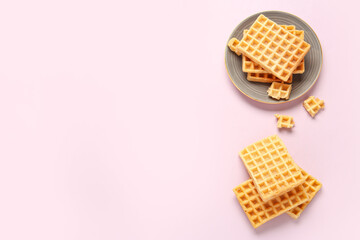 Plate with tasty Belgian waffles on pink background
