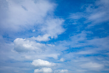 Obraz premium A Clear Blue Sky adorned with Fluffy White Clouds stretches endlessly across the horizon