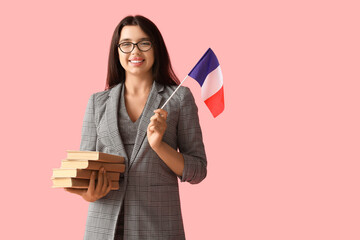 Female French language teacher with books and flag on pink background