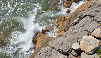 Fototapeta premium Waves crashing on rocky shore, dynamic ocean landscape