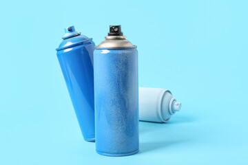 Spray paint cans on blue background