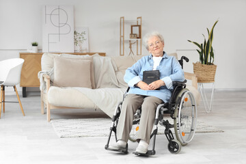 Senior woman in wheelchair with Bible at home